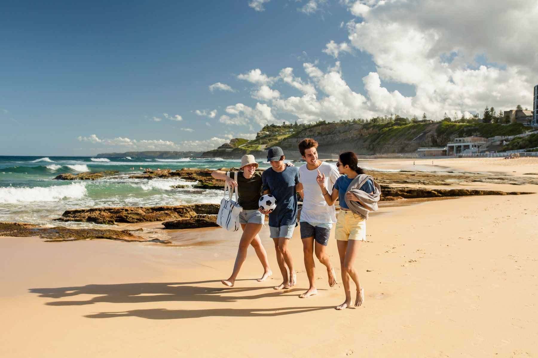 Friends walking on the beach in Newcastle