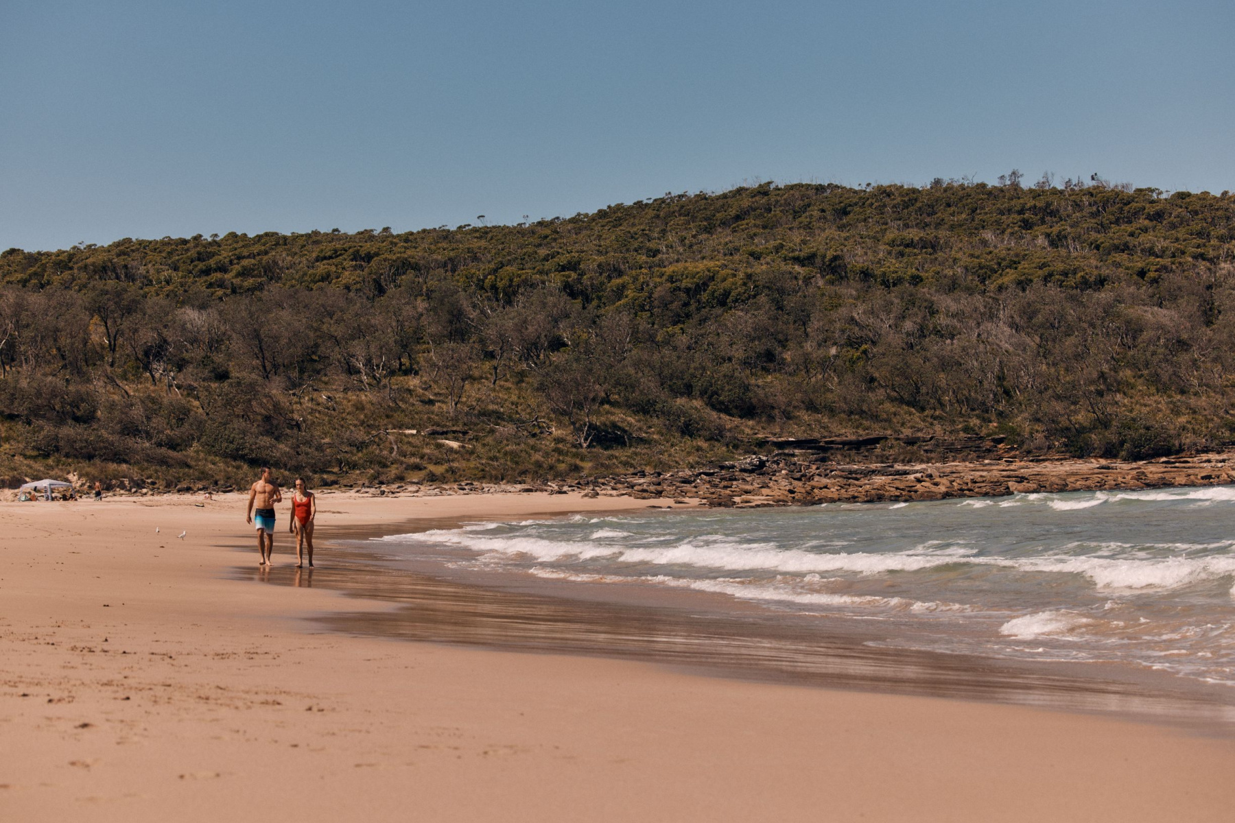 Couple walking on beach in Shoalhaven