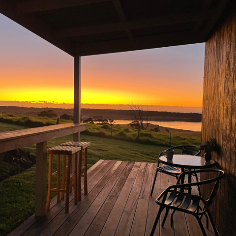 sunset on a tiny house deck looking over a lake